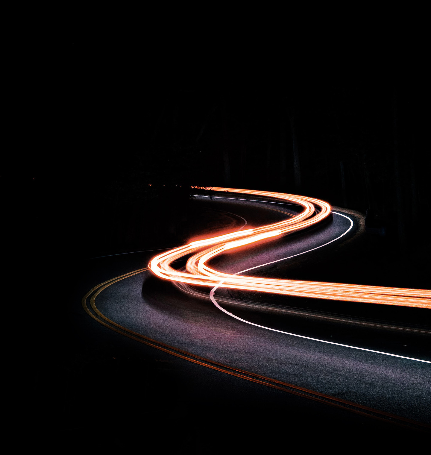 Light trails on a winding road at night